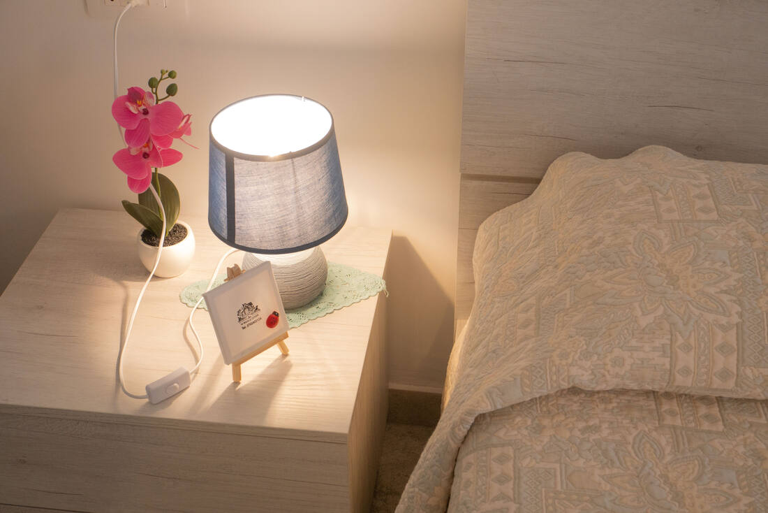 Comodino con orchidea e lampada