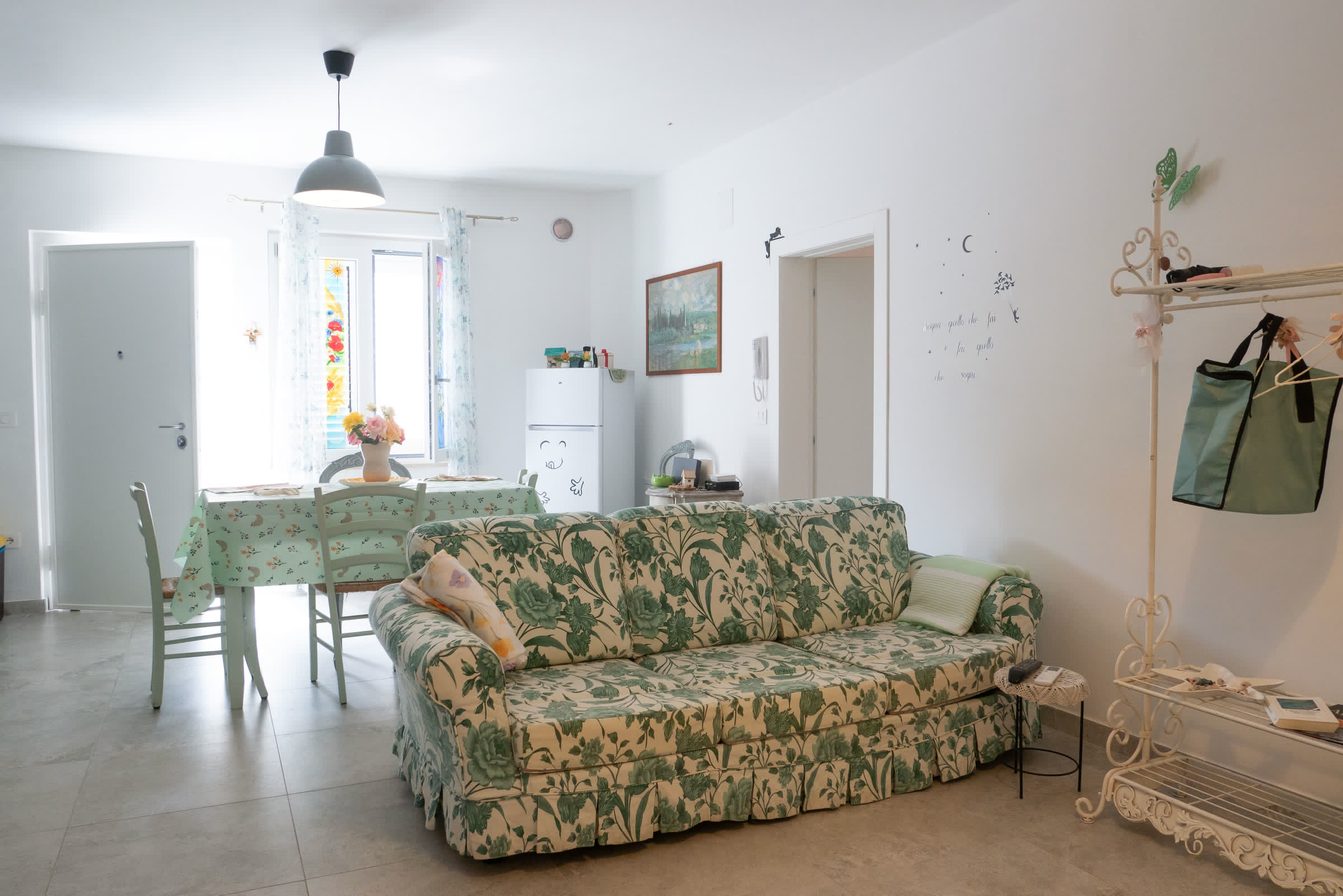 Soggiorno con divano floreale e zona pranzo